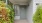 the entrance of a home with bushes
