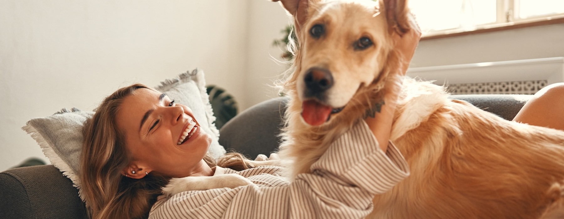a woman lying on a couch with a dog