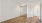 a large, empty bedroom with a mirror and wood floors